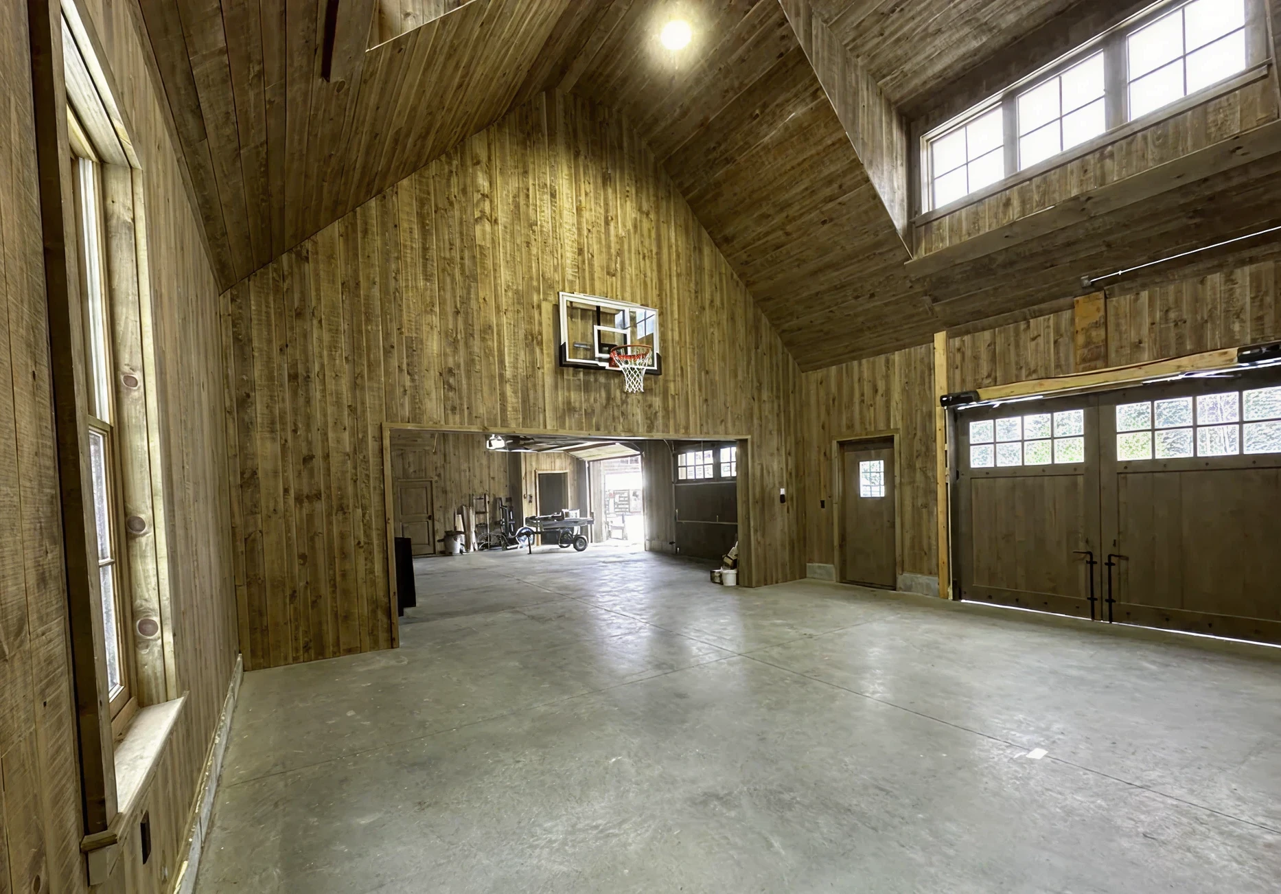 Wooden garage with basketball hoop inside.