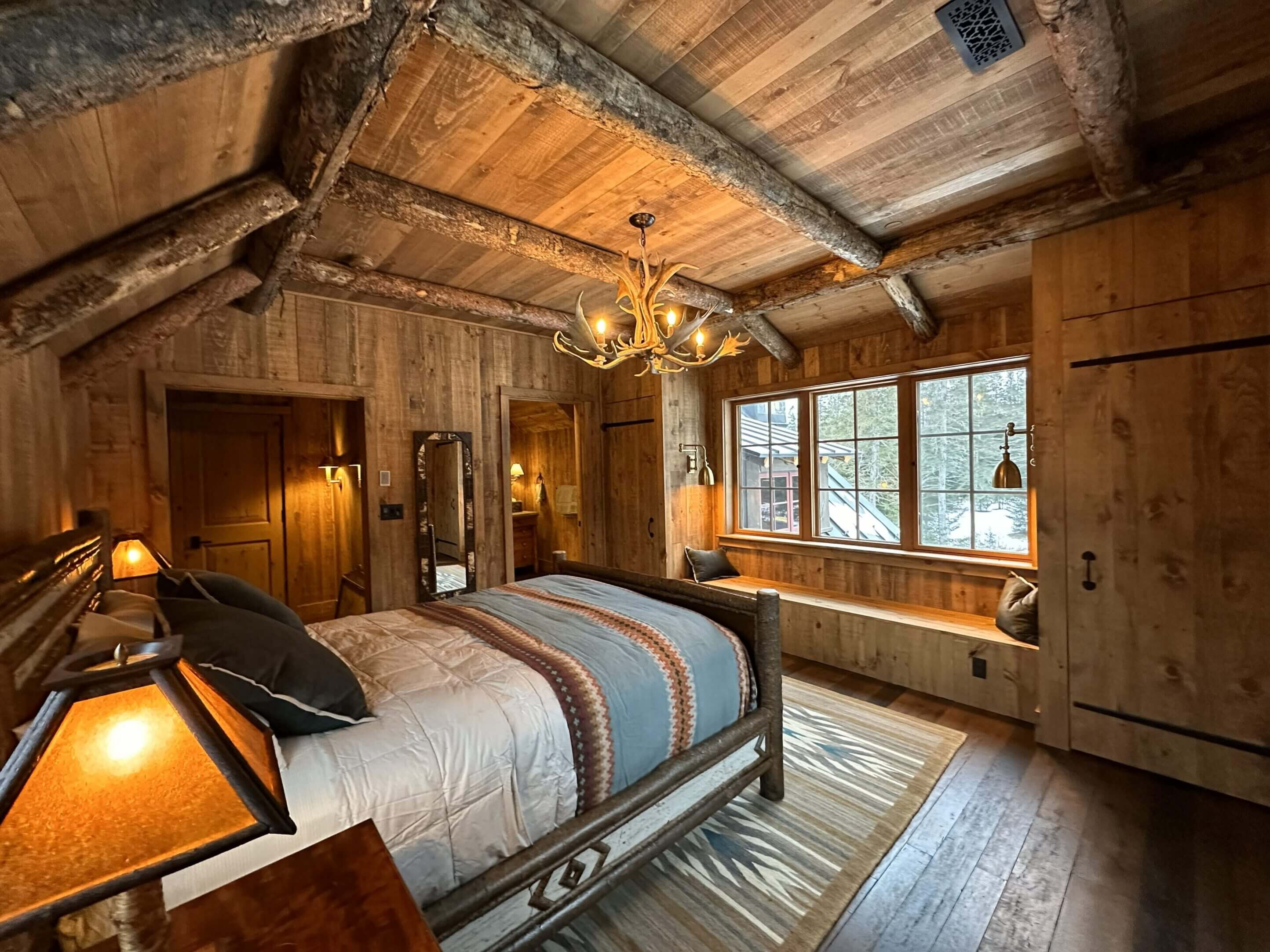 Rustic bedroom with wooden decor and lighting.